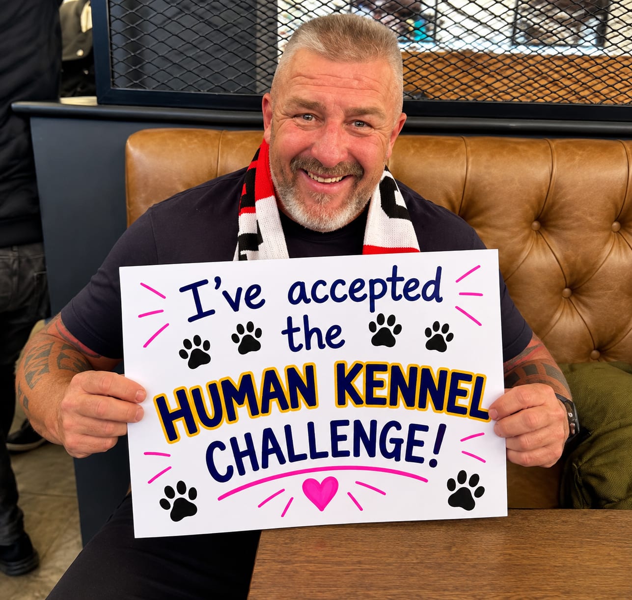 Big Phil Campion holding his "I've accepted the Human Kennel Challenge" board
