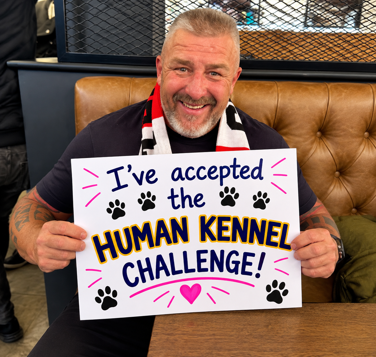 Big Phil Campion holding his "I've accepted the Human Kennel Challenge" board
