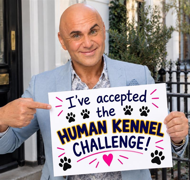 Simon Gross pointing at his "I've accepted the Human Kennel Challenge" board